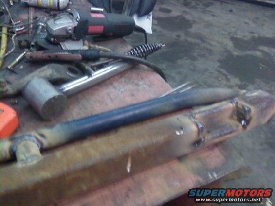 Welded steel rock sliders on a workbench with tools