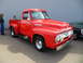 1956 Ford Fairlane - This red 1956 Ford F-100 pickup truck is parked next to another vehicle.