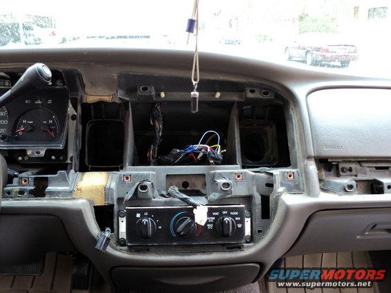 Dashboard of a 2001 Mercury Grand Marquis with center console removed, showing wiring and climate controls