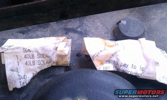 Two torn receipts and a black cap on a dirty surface