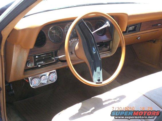 1979 Ford Ranchero interior with wood grain dash, tan steering wheel, and triple gauges
