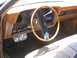1979 Ford Ranchero - The interior of a 1979 Ford Ranchero features a wood-grain dashboard, a tan steering wheel, and auxiliary gauges below the radio.