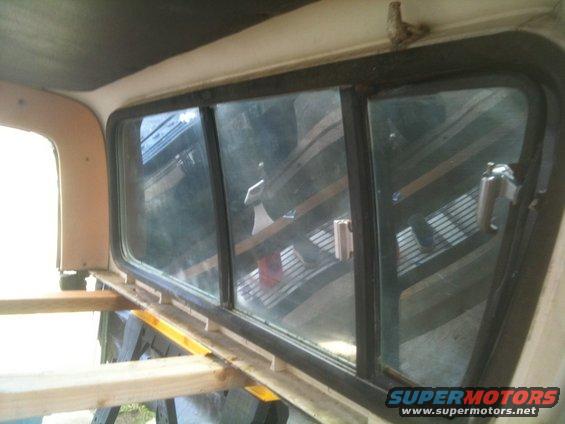 Interior view of a vehicle's rear window frame with wooden supports