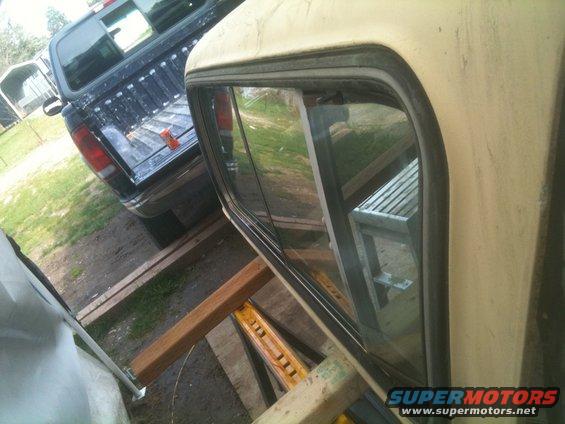 Rear of black pickup truck with orange object in bed