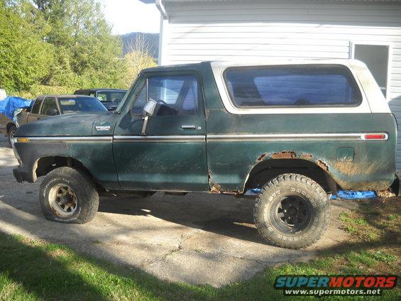 Green and white SUV side view, showing rust and flat tire. Appears to be a 1978 Ford Bronco