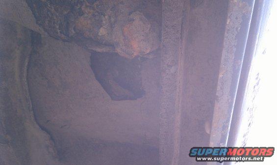 Close-up of heavily rusted metal frame, possibly from a vehicle undercarriage
