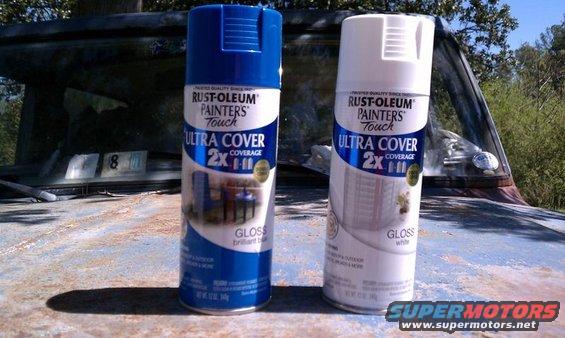Two cans of Rust-Oleum spray paint on a rusty car hood. The car appears to be old and in disrepair