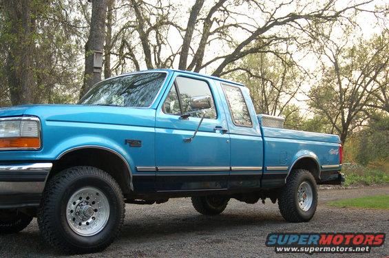 1992 Ford F-150 pickup truck, side view, blue exterior, aftermarket wheels