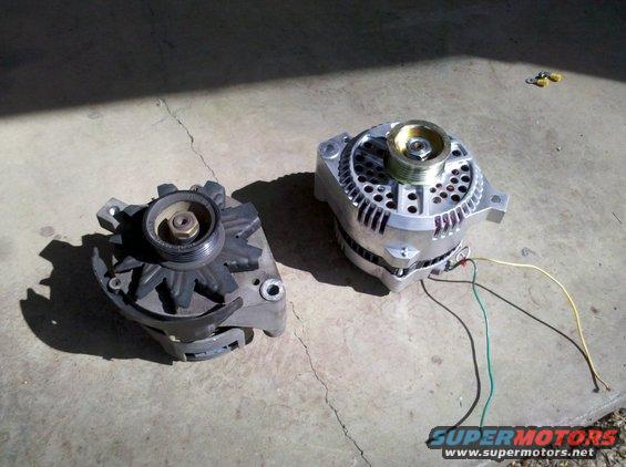 Two alternators, one old and one new, on a concrete surface