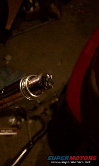 Close-up of a fouled spark plug with carbon buildup
