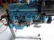 1978 Pontiac Trans Am - Close-up view of a blue engine block and exhaust manifold mounted on a stand.