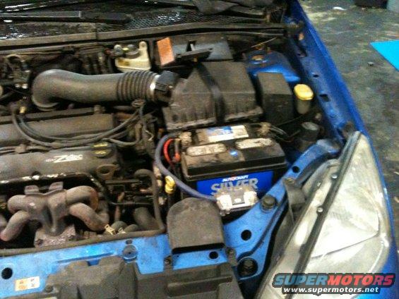 2002 Ford Focus engine bay showing battery, air intake, and exhaust manifold