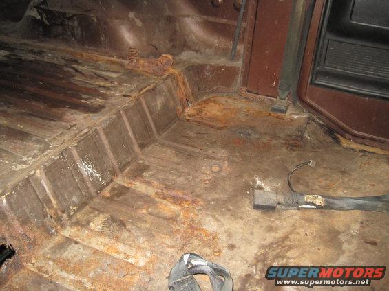 Rusted interior floor with seatbelt hardware