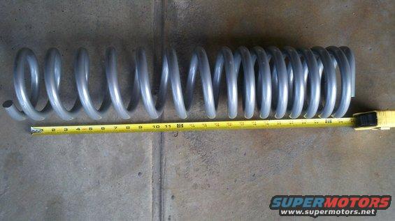 Gray coil spring measured with a yellow tape measure