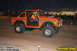1995 Ford Bronco - A modified orange Bronco with a roll cage and large tires is seen on a dirt track at dusk.