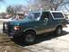 1989 Ford Bronco - This 1989 Ford Bronco features a two-tone paint scheme with a tan removable top and a prominent front brush guard.