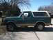 1989 Ford Bronco - Side view of a green 1989 Ford Bronco, tan trim and off-road tires.
