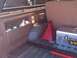 1989 Ford Bronco - Vehicle interior cargo area contains cleaning supplies, a jack, and a toolbox.