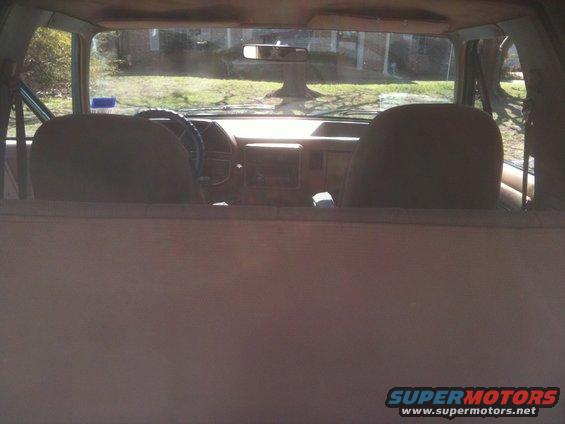 Interior view of a Ford Bronco, looking forward from the back seat. Dashboard and steering wheel visible