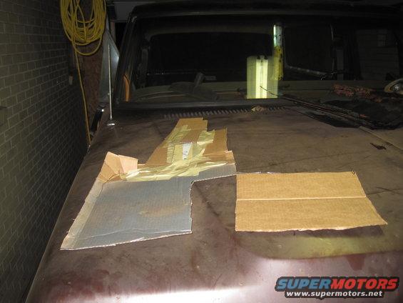 Cardboard templates on a dark red car hood