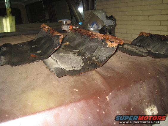 rusted metal pieces on a car hood, possibly from a fender or undercarriage