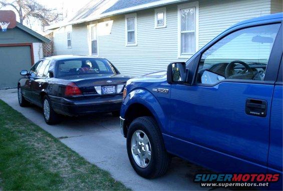 Dark blue Ford Crown Victoria parked next to a blue Ford F-150 pickup truck