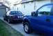2008 Ford Crown Victoria - A dark blue sedan is parked in a driveway next to a blue pickup truck.
