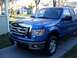 2008 Ford Crown Victoria - This blue Ford F-150 pickup truck has a chrome grille and is parked in a driveway.