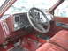 1994 GMC Sierra 3500 - The interior of a 1994 GMC Sierra 3500 features a red velour bench seat and a dashboard with a prominent steering wheel and instrument clus…