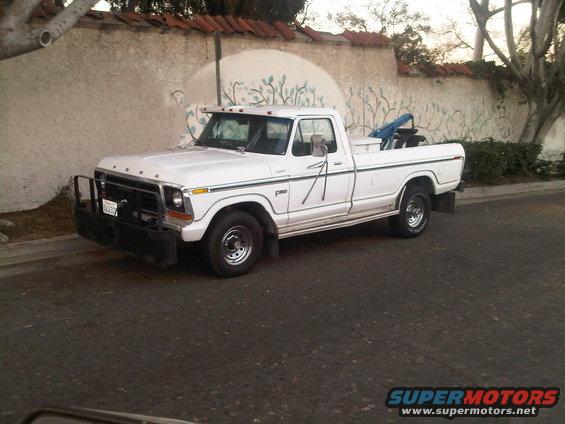 White Ford F-series pickup truck, looks like a 1979 model, parked on a street