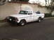 1986 Ford Bronco - This white Ford pickup truck, likely from the late 1970s, is parked in front of a stucco wall with a mural.