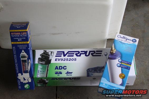 Three water filter boxes: Hydro Life, Everpure, and Culligan, arranged on a surface