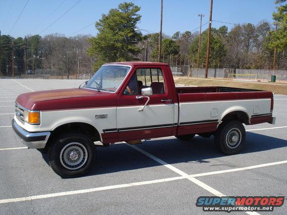 Two-tone red and white Ford F-series pickup truck, side view. Looks like an early 90s model