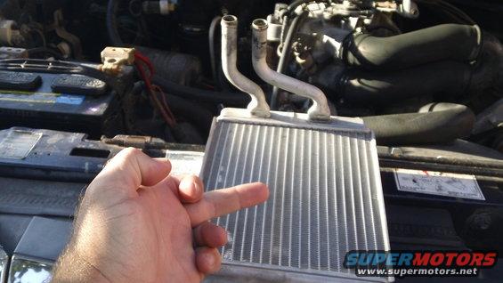 1994 Ford Bronco heater core held in front of engine bay