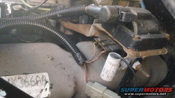 Close-up of engine wiring and a black electrical component with some rust
