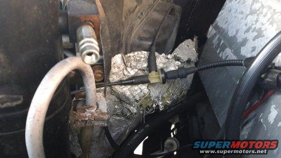 Engine bay view of AC lines and sensor connectors with insulation