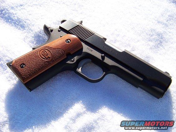 Colt 1911 pistol with wood grips and Colt logo, on a white surface