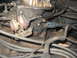 1982 Ford Bronco - Close-up view of a vehicle's engine carburetor, highlighting its mechanical components and wear.