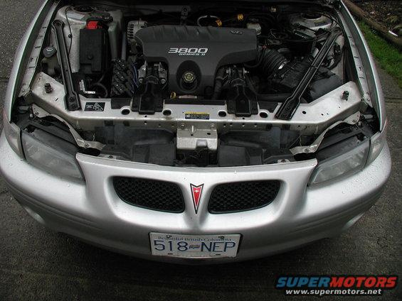 Silver 2002 Pontiac Grand Prix engine bay with 3800 Series II engine visible. Front grille and license plate are also in view
