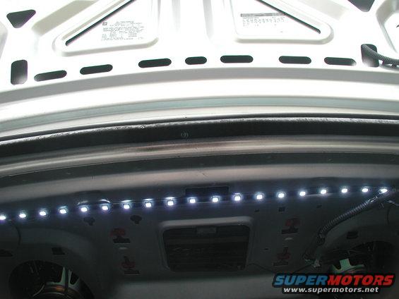 Trunk interior showing a strip of white LED lights installed along the top edge