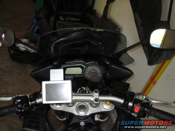 Motorcycle handlebars, dashboard, and GPS mount. Speedometer visible