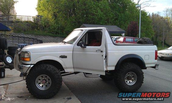 1996 Ford Bronco, lifted with oversized tires, driver's door open