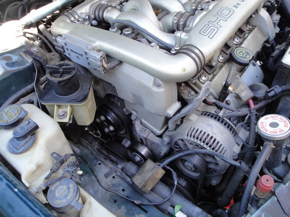 Close-up of a Ford SHO 24-valve V6 engine, showing the intake manifold, alternator, and various hoses and belts