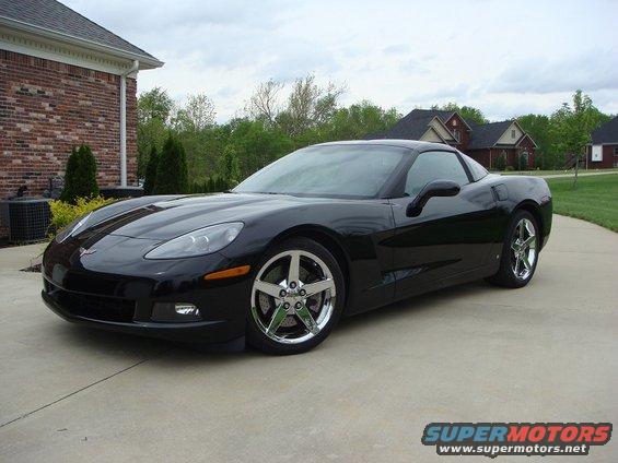 Black Chevrolet Corvette parked on a driveway in front of a house