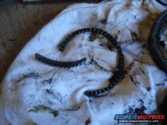Broken timing chain on white cloth with oil stains