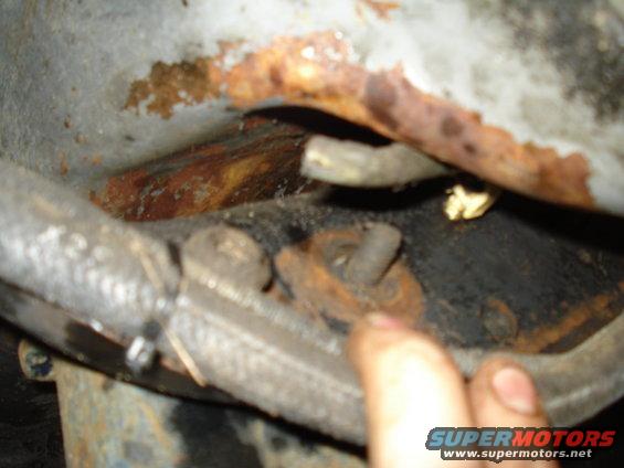 Close-up of a rusted bolt and bracket on a vehicle's suspension system