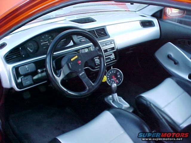 Interior view with aftermarket steering wheel and gauge