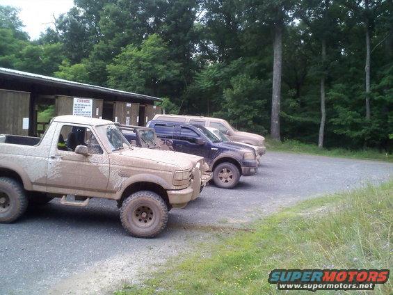 Mud-covered 1995 Ford Bronco parked next to two other SUVs