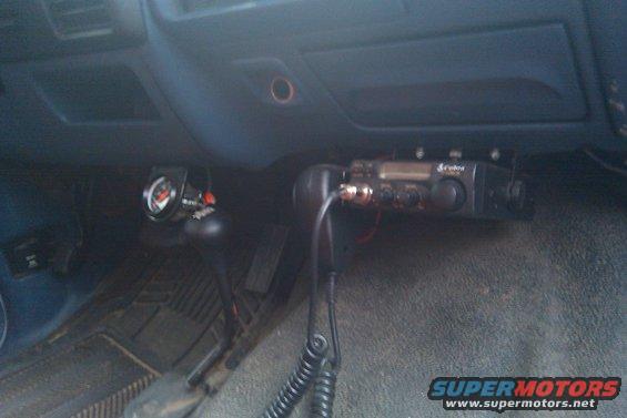 Vehicle interior showing a Cobra CB radio and a gauge mounted near the gear shifter