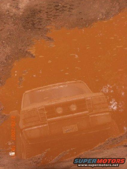 1996 Ford Bronco rear view stuck in orange mud puddle
